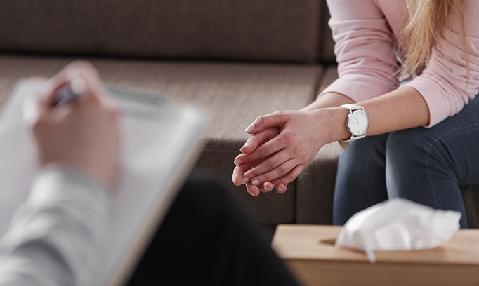 woman sitting (shown from shoulders down) with hands relaxed and in front of her talks to therapist about her personality disorder