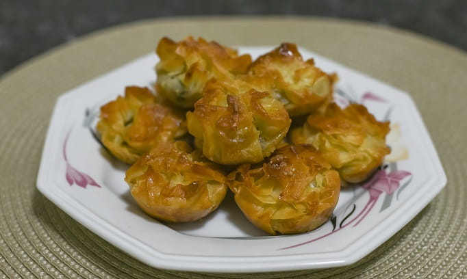 seven apple pie bite desserts piled on a white plate 682x408
