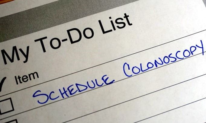 paper to-do list with 'schedule a colonoscopy' written on the top line