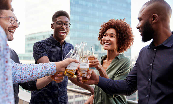 Group of five people socially drinking and cheering their drinks
