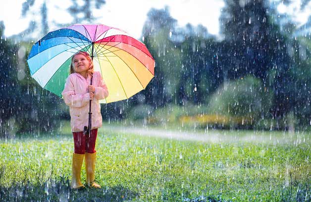 girl with rainbow umbrella in light rain during coronavirus quarantine