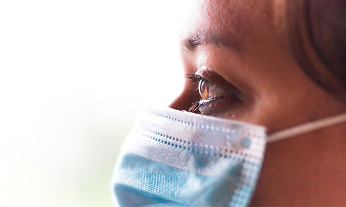 woman wearing a mask looking away in hope