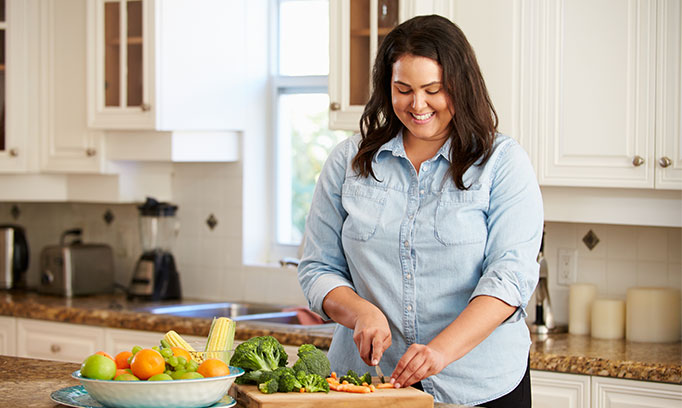 Woman cutting vegetables to prepare a healthy meal to lose weight with diabetes