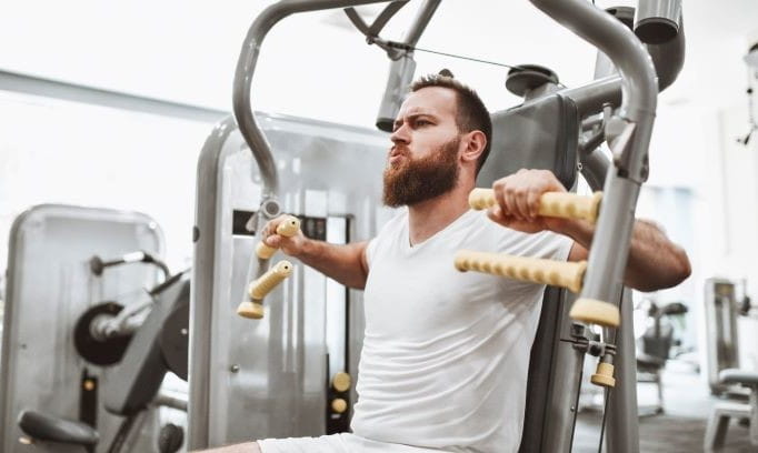 man in white t-shirt using exercise equipment in gym to improve lung power
