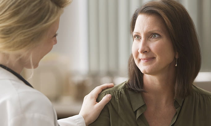 female doctor touches female patient's shoulder as she explains pelvic organ prolapse