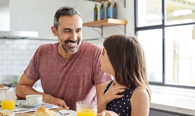 A father talks to his middle school age daughter at the breakfast table about LGBTQ+ issues