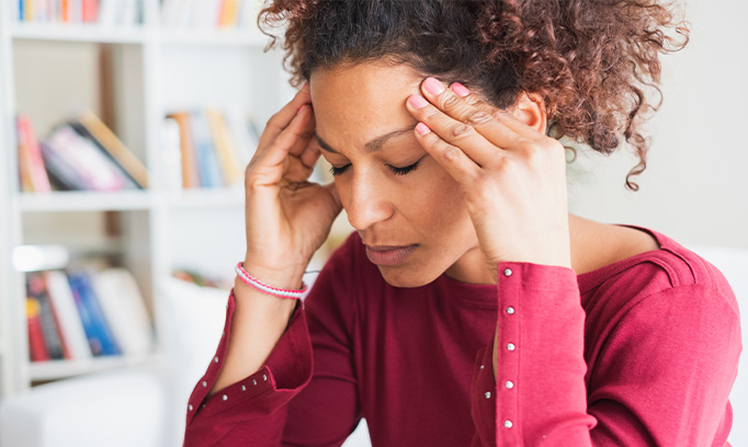 woman with headache pain holding her head