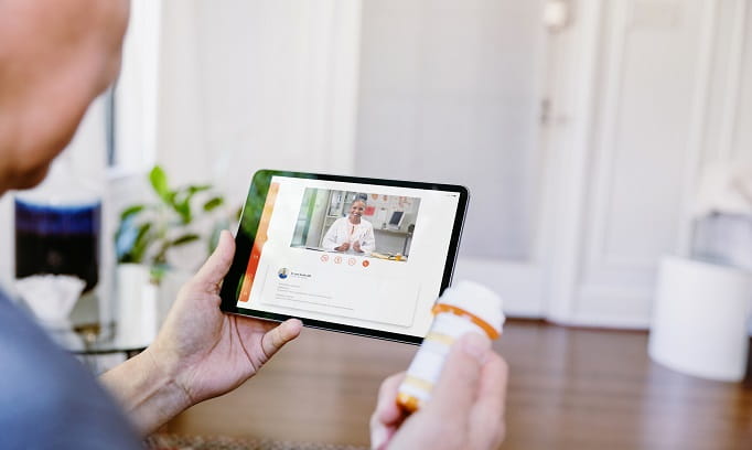 Woman checking using her table for a virtual visit 682x408