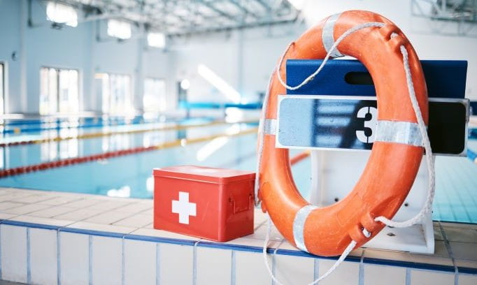 water floatation ring and first-aid kit on floor in front of pool