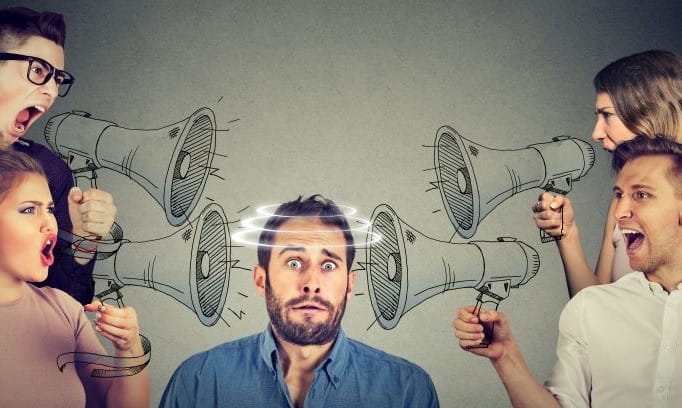 four people screaming in megaphones at scared guy with political anxiety