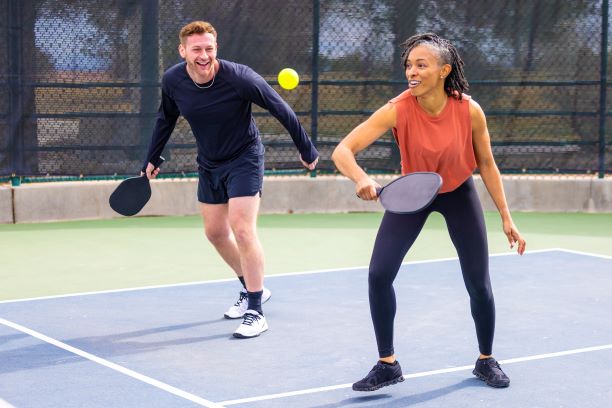 Man and woman playing doubles pickleball