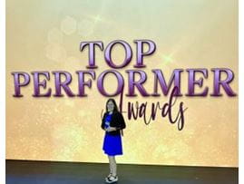 Adult with award on stage at Visient conference